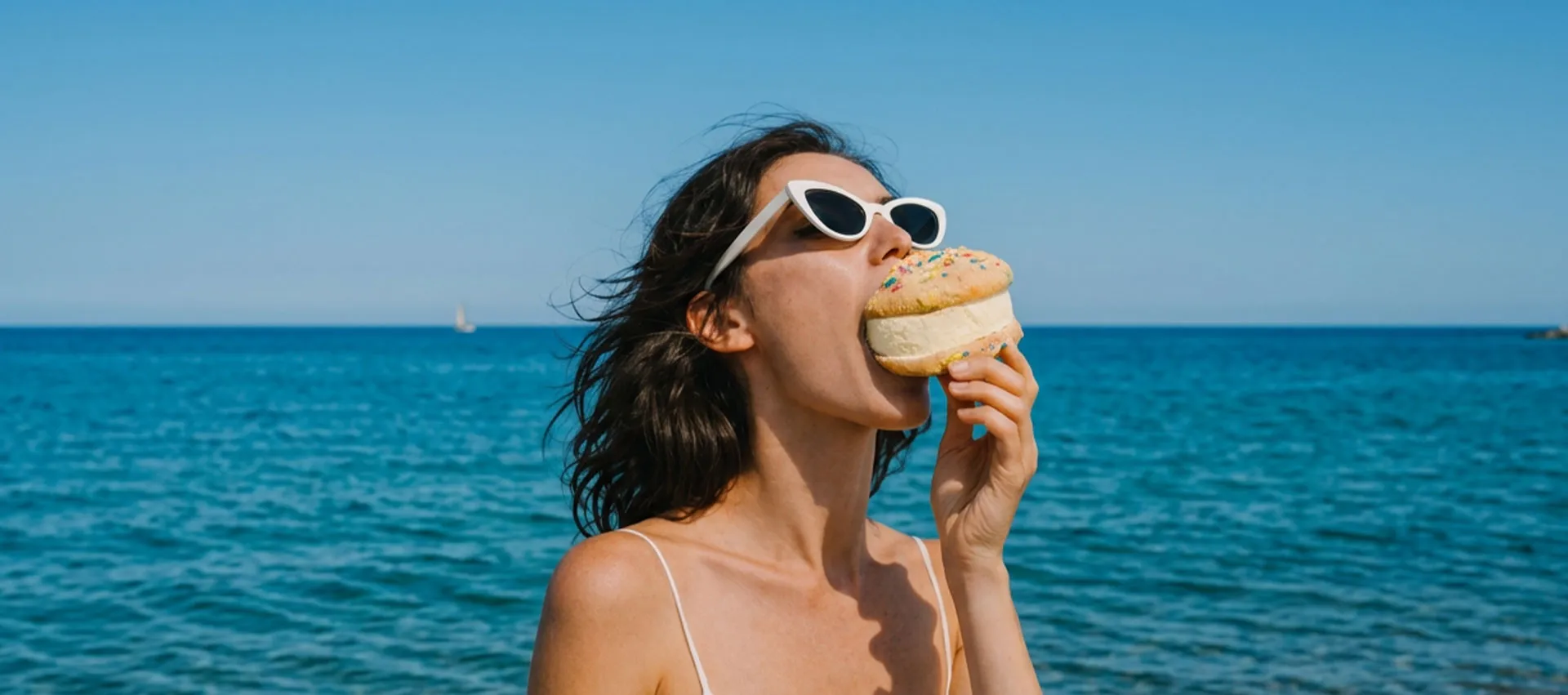 Girl taking a huge bite of Cookies and Cream Smiley World Vanilla ice cream sandwich